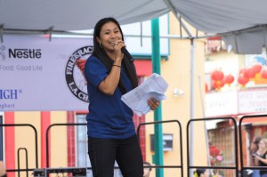 Michelle Wong hosting the Nite 'n Day Chinatown Firecracker festival on stage with a microphone