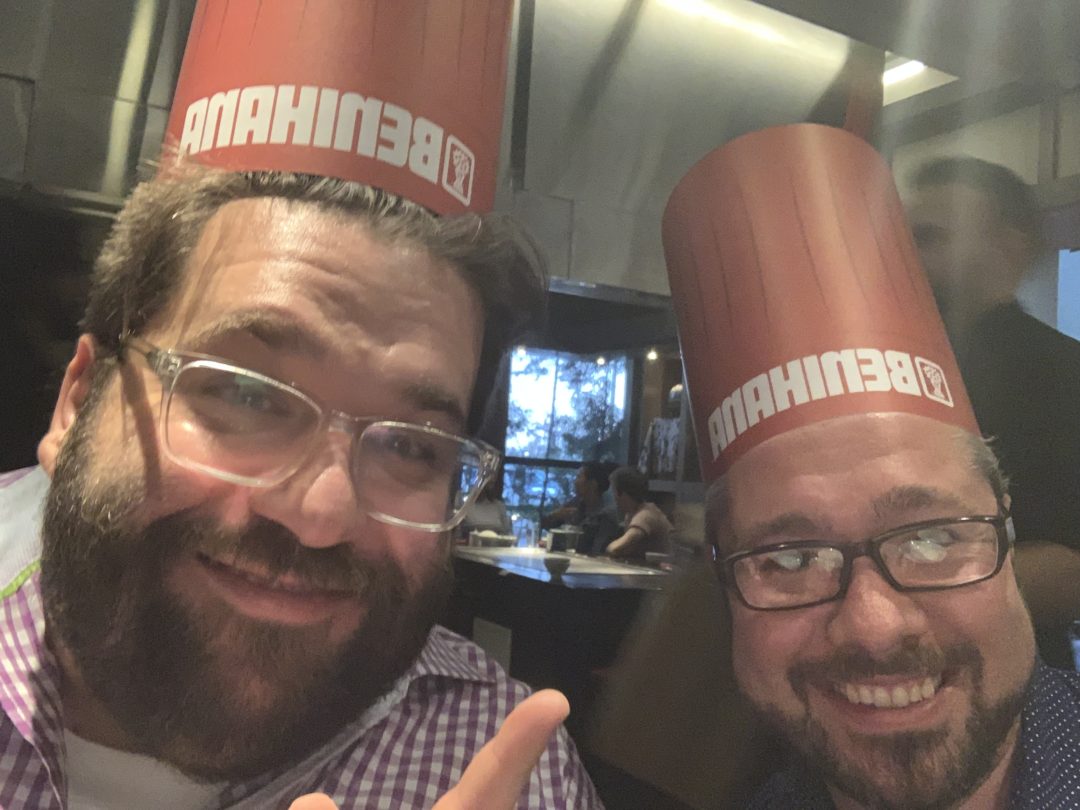Michelle Wong and a friend holding Benihana-branded drinks, photographed upside down
