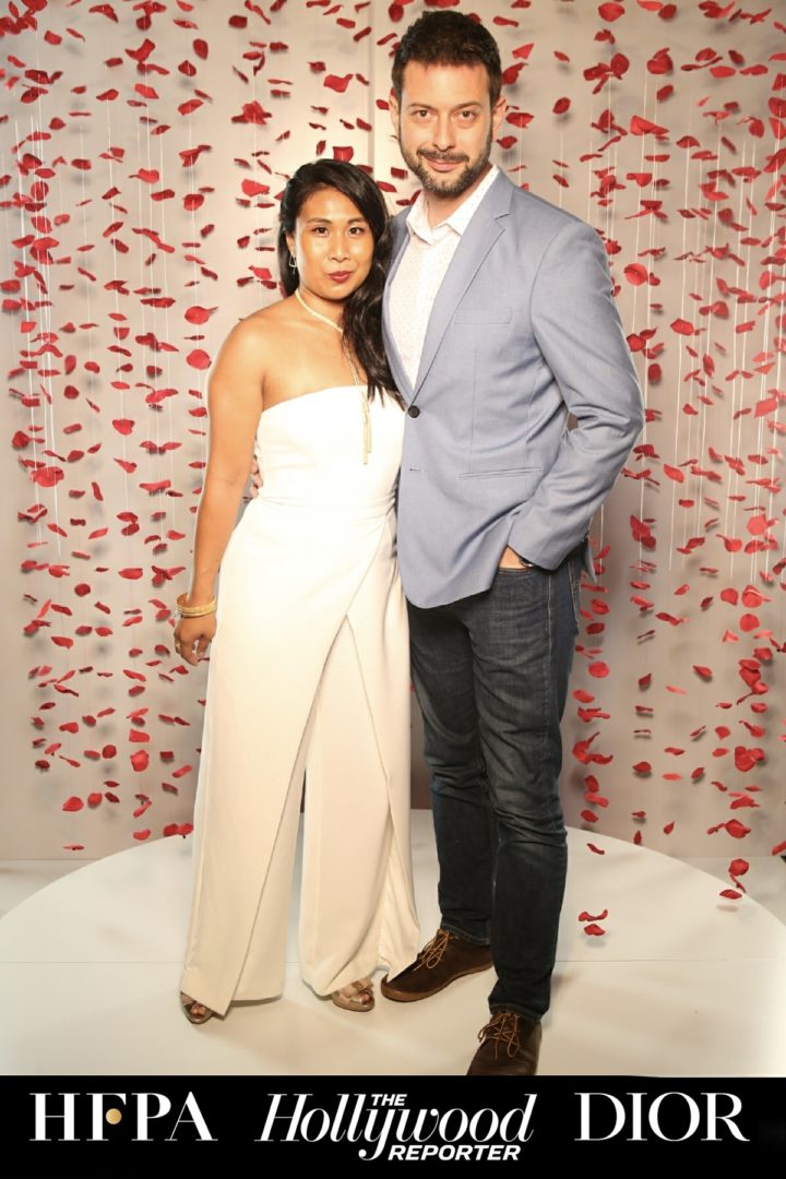 Michelle Wong and her husband at a TIFF event step-and-repeat with HFPA, The Hollywood Reporter, and Dior branding