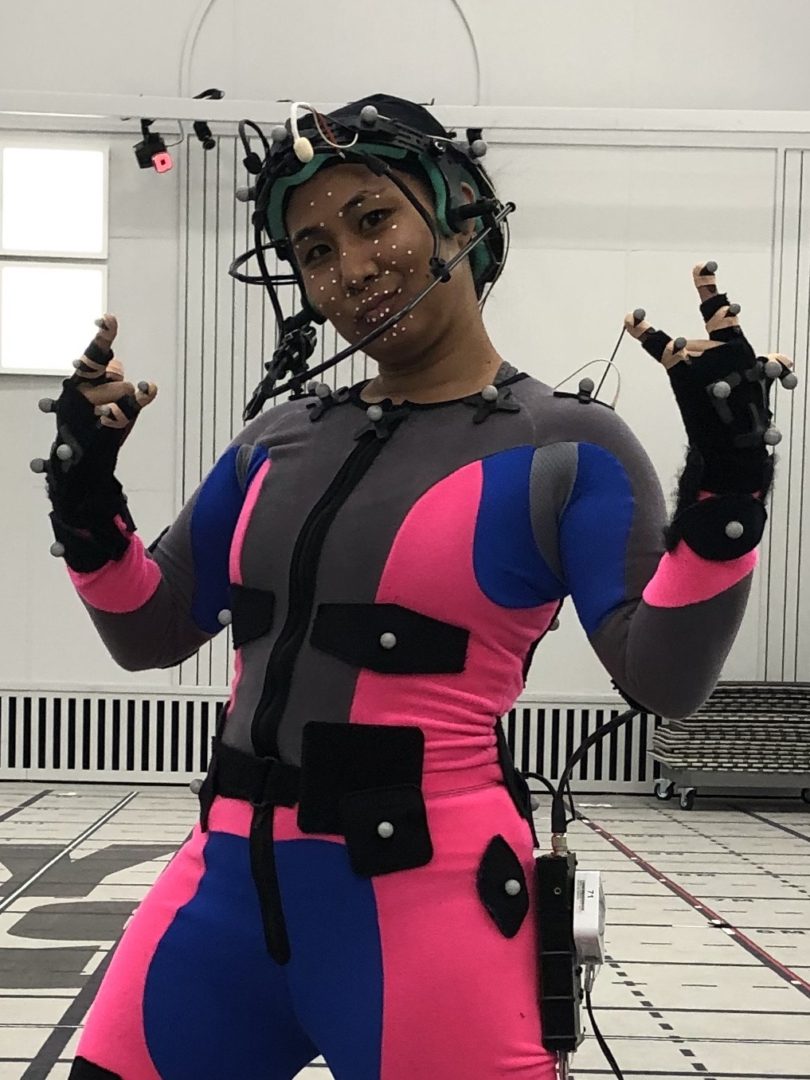 Michelle Wong suited up in a full motion-capture rig with facial markers and a headset camera